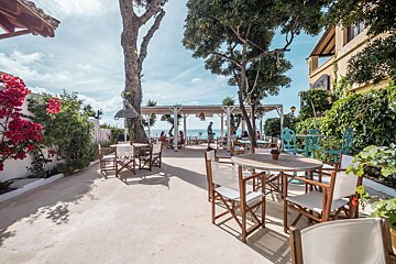 A restaurant with tables and chairs in front of it