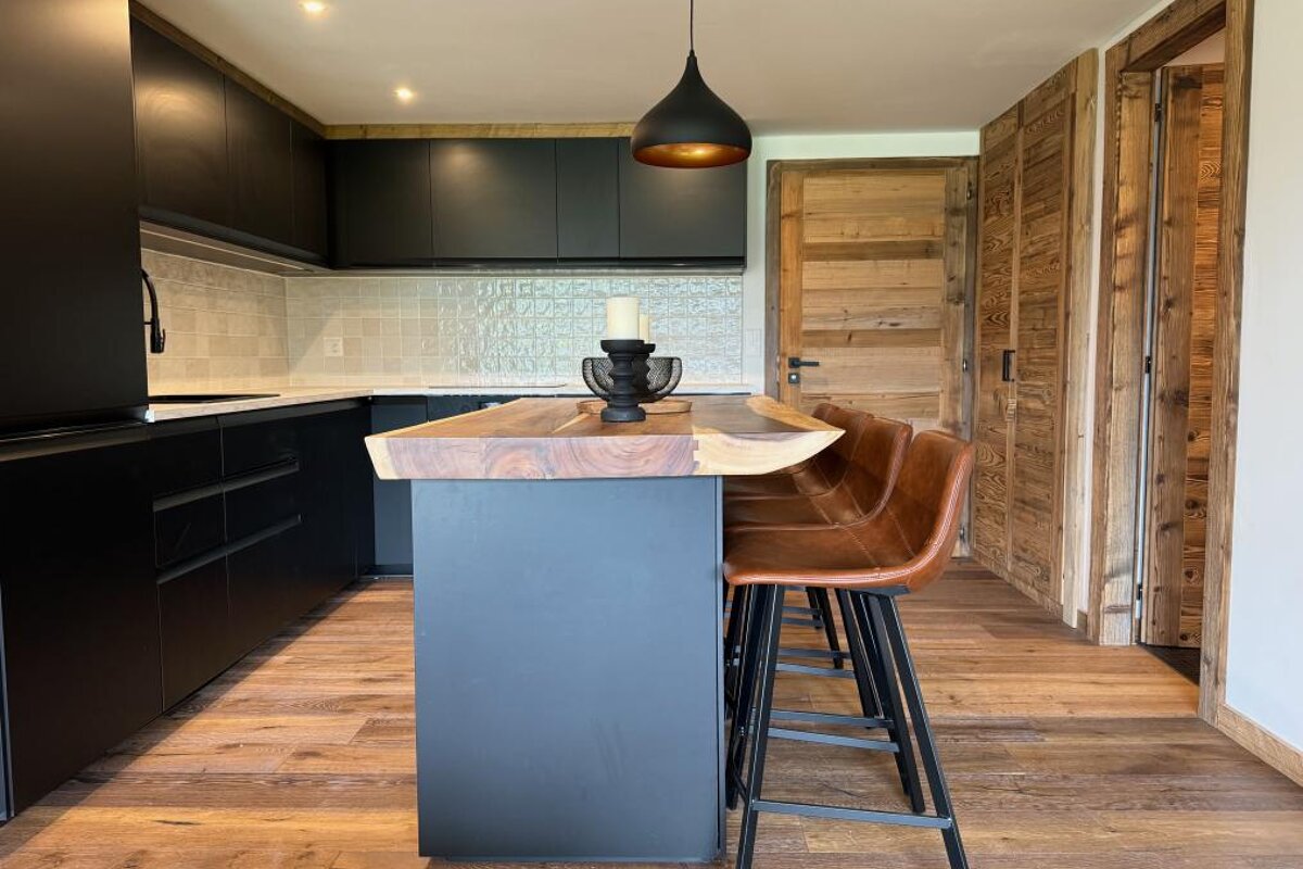 A kitchen with black cabinets and a wooden counter top