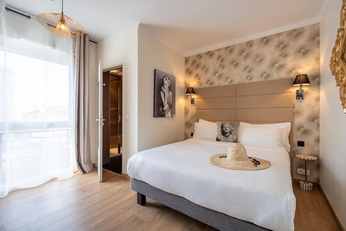 A hotel room with a bed and a picture of marilyn monroe on the wall