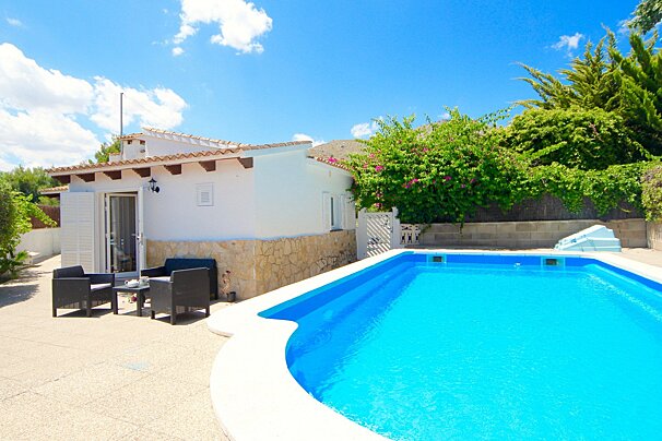 A house with a swimming pool in front of it
