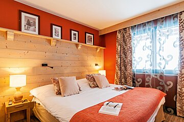 A hotel room with a bed and a book on the bed