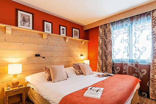 A hotel room with a bed and a book on the bed