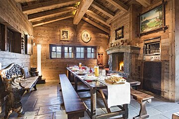 A dining room with a long table and a fireplace