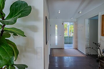 A hallway with a plant and a white door