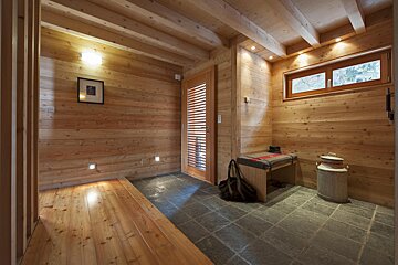 A wooden hallway with a bench and a picture on the wall