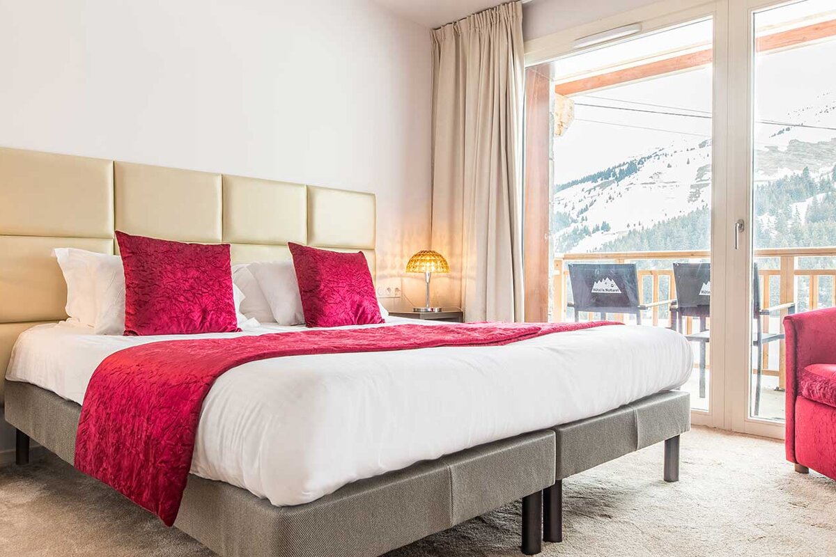 A hotel room with a large bed and a balcony