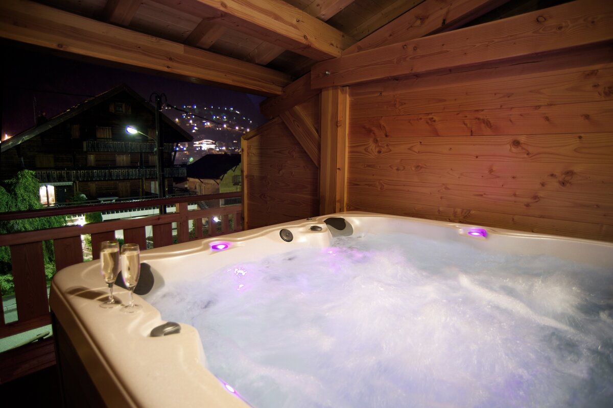A hot tub with two glasses of champagne in it