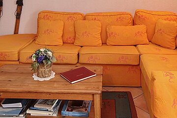 A living room with a couch and a table with books on it