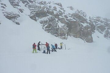 a group of skiers taking their skins off