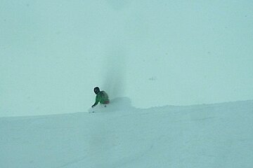 a man in green jacket skiing