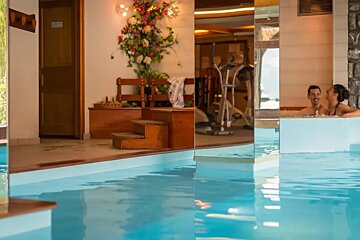 A man and a woman are sitting in a swimming pool