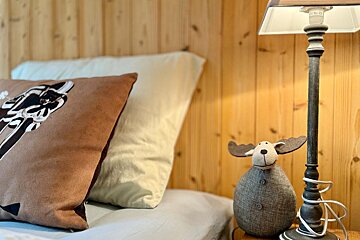 A moose lamp sits next to a pillow on a bed