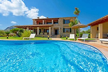 A large house with a swimming pool in front of it