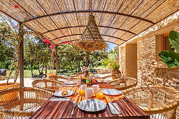 A table with plates and utensils on it under a canopy