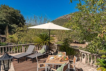 A patio with a table and chairs under an umbrella