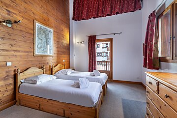 A bedroom with two twin beds and a dresser
