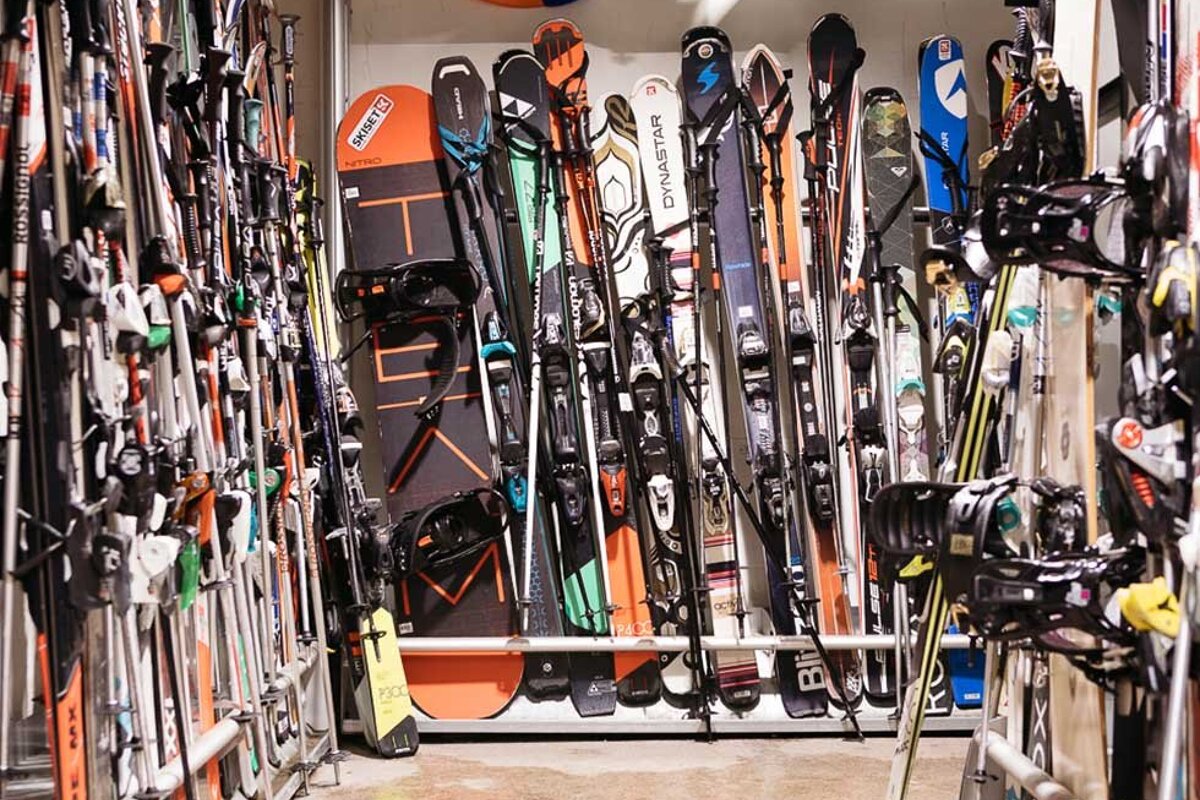A bunch of skis and snowboards including one that says dynastar