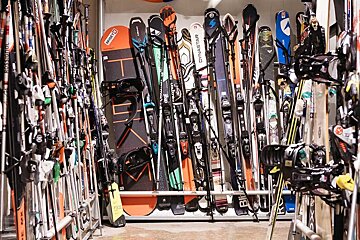 A bunch of skis and snowboards including one that says dynastar