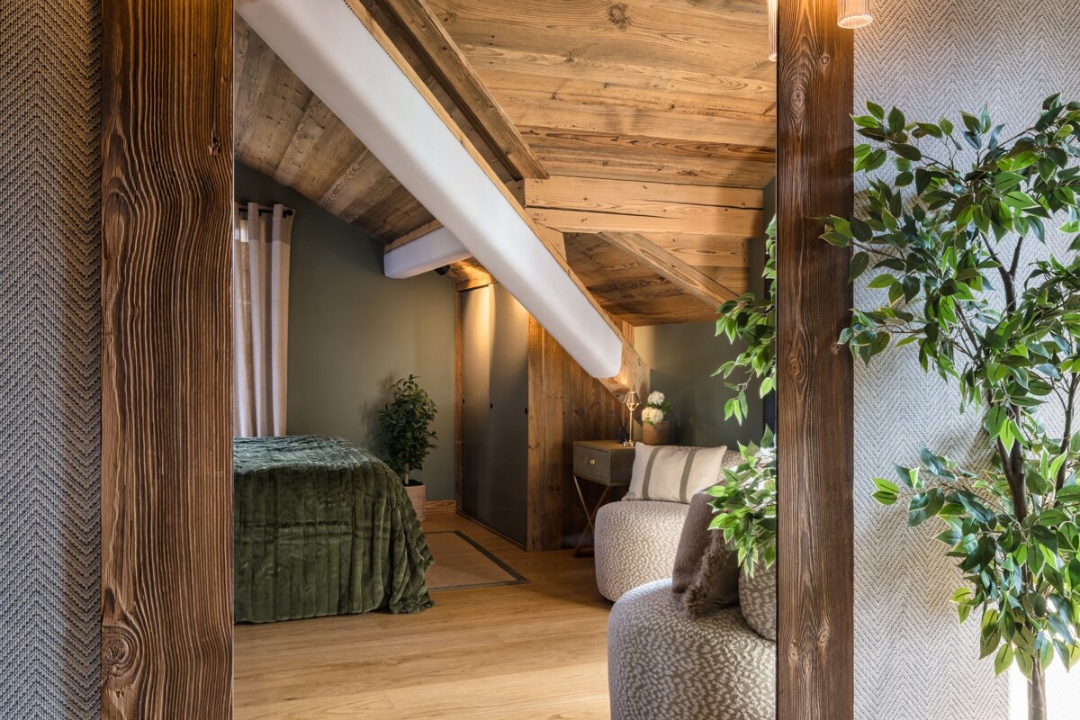 A bedroom with a bed and a chair in it