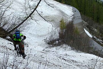 A person riding a bike down a snowy hill