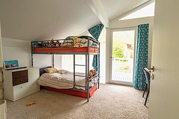 A bedroom with a bunk bed and a desk