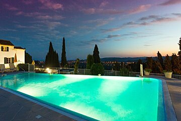 A large swimming pool is lit up at night