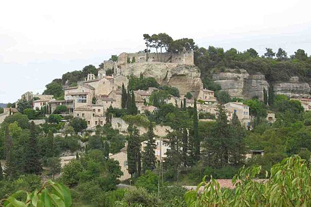 A small town sits on top of a hill surrounded by trees