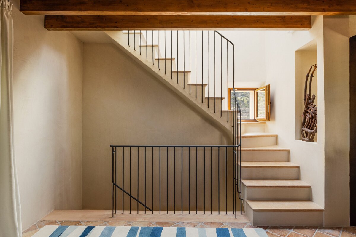 A staircase with a striped rug on the floor