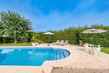 A swimming pool with a table and chairs and an umbrella