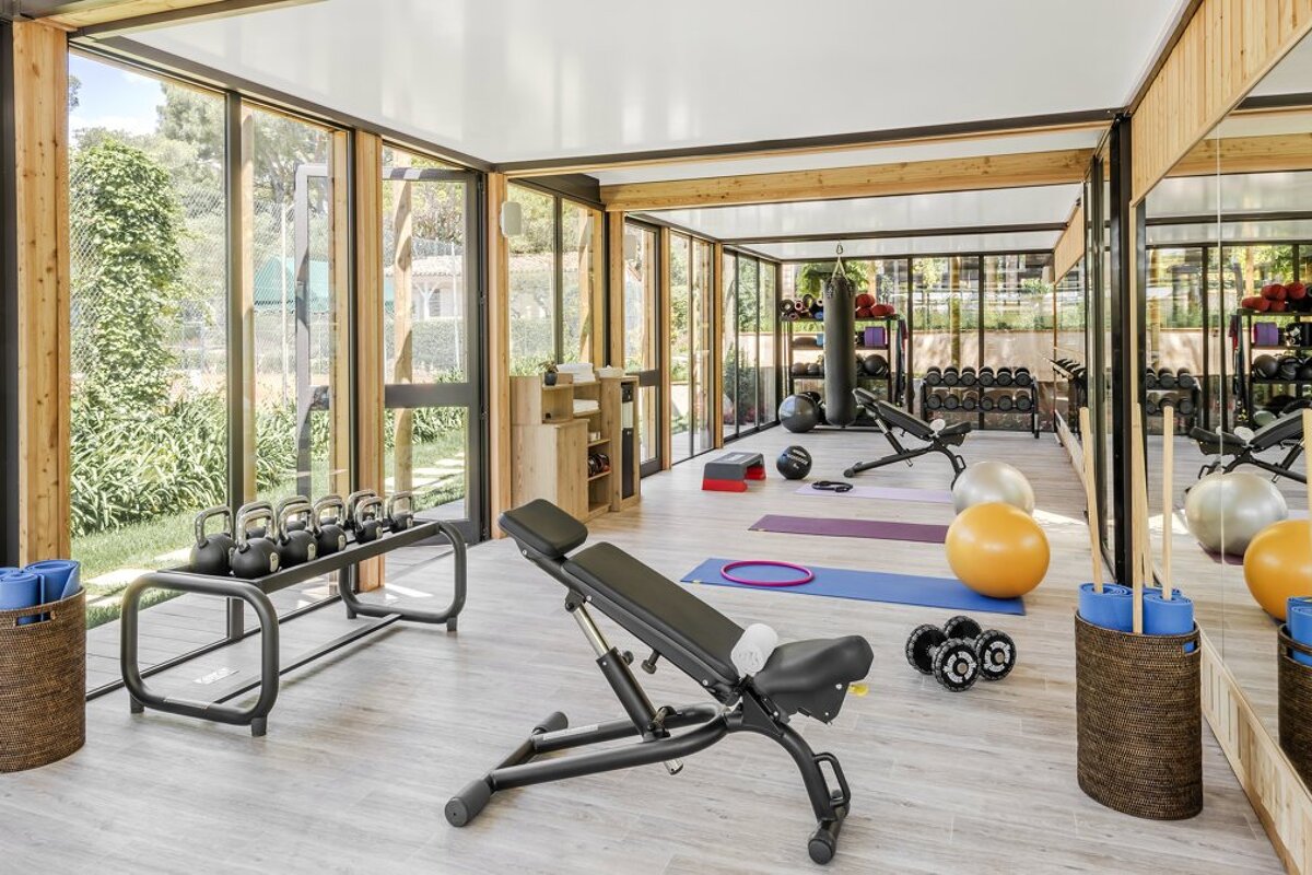 A gym with a lot of windows and exercise equipment