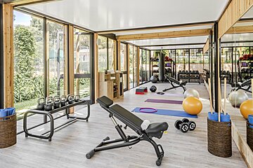A gym with a lot of windows and exercise equipment