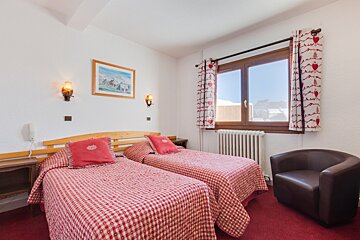 A hotel room with two beds and a chair
