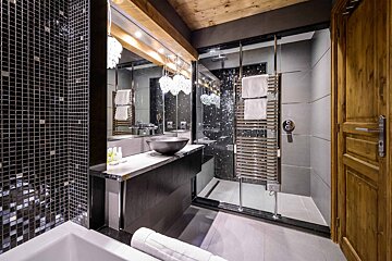 A bathroom with a sink and a walk in shower