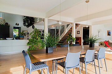A dining room table with chairs and plants on it