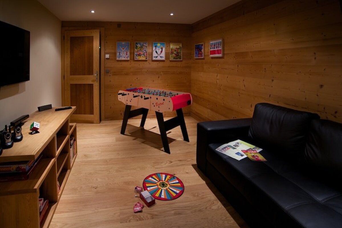 A game room with a foosball table and a couch