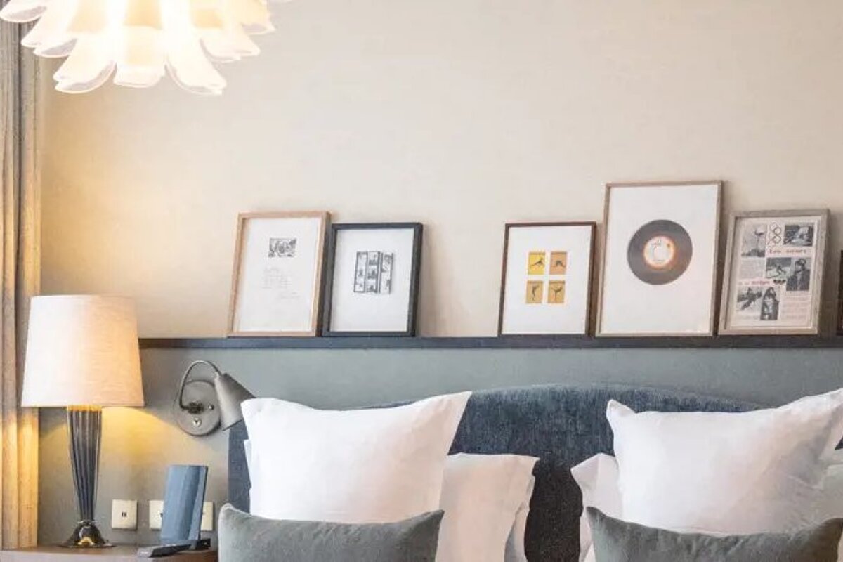A bed with a newspaper on the wall above it