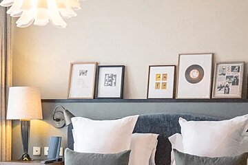 A bed with a newspaper on the wall above it