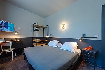 A hotel room with a bed and a tv that says pub