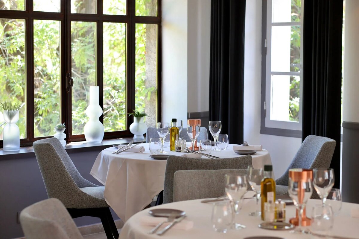 A bottle of olive oil sits on a table in a restaurant