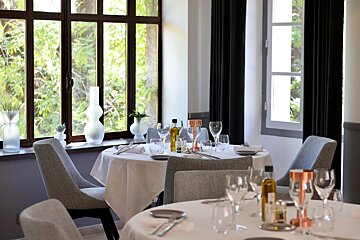 A bottle of olive oil sits on a table in a restaurant