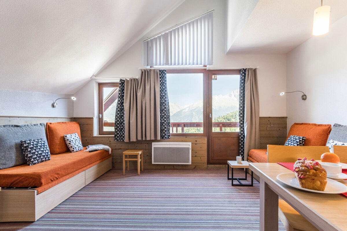 A living room with a couch and a table with a muffin on it