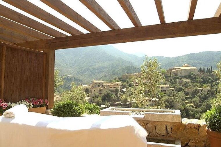 A massage table with a view of a village in the mountains
