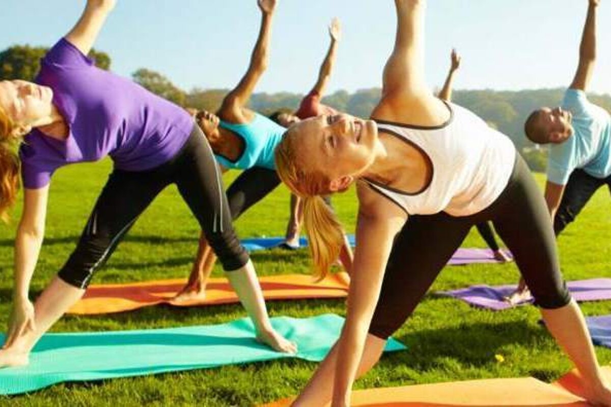 A group of people are doing yoga in a park