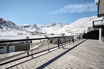 A balcony with a view of snow covered mountains