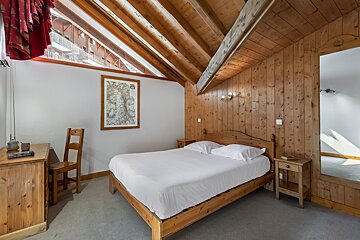 A bedroom with a map on the wall above the bed