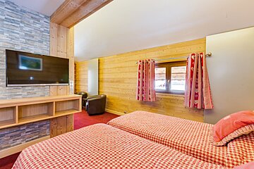 A bedroom with two beds and a flat screen tv