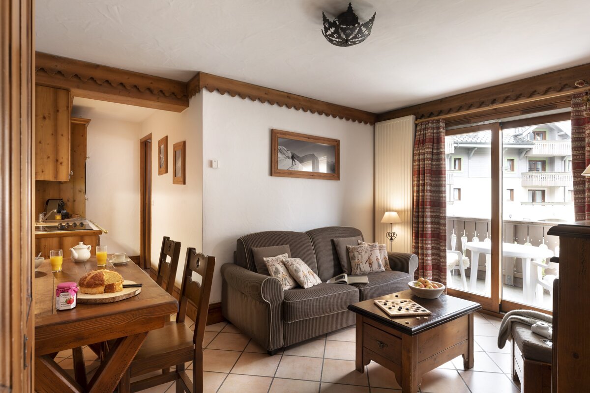 A living room with a couch and a table with a jar of jam on it
