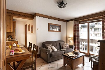 A living room with a couch and a table with a jar of jam on it