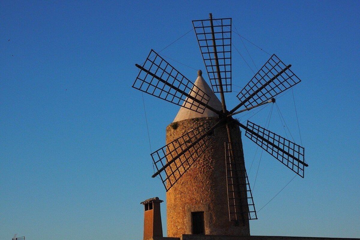 A windmill with a blue sky in the background