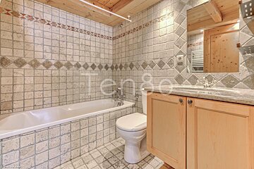 A bathroom with a toilet and bathtub and the word tengo on the wall